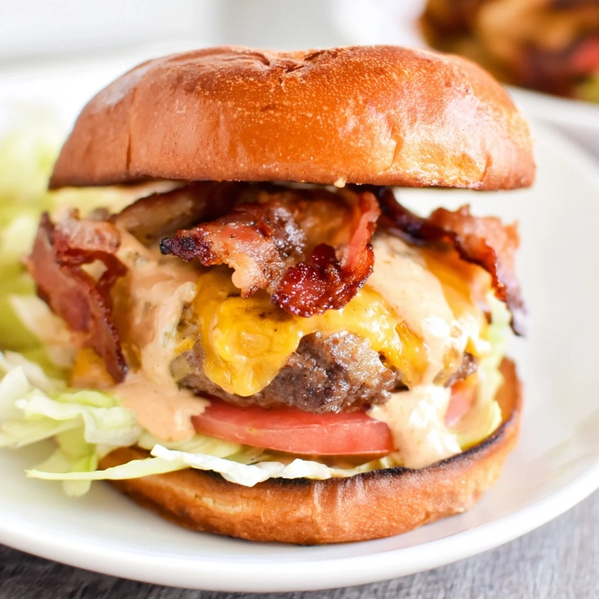 Juicy Crack Burgers stacked with crispy bacon, melted cheddar cheese and fresh vegetables on toasted buns