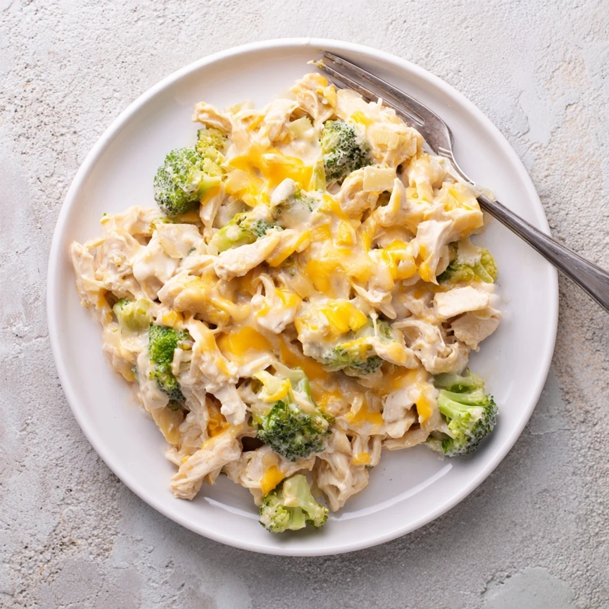 Slow cooker creamy broccoli cheddar chicken with tender shredded meat in rich cheese sauce