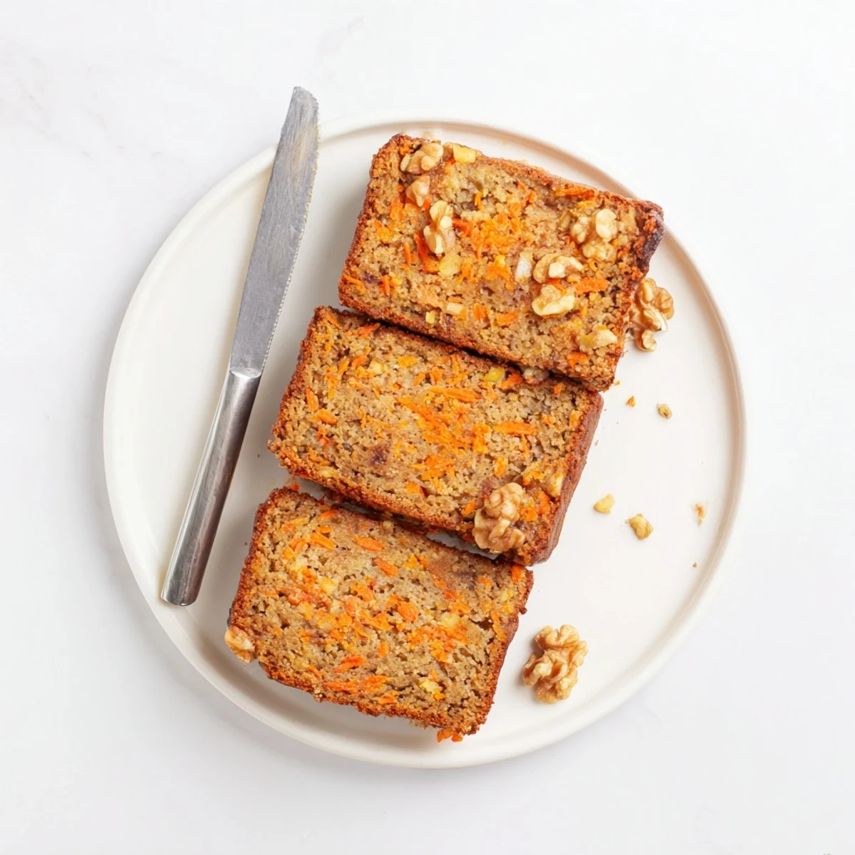 Moist carrot cake banana bread loaf with walnuts on a wooden cutting board