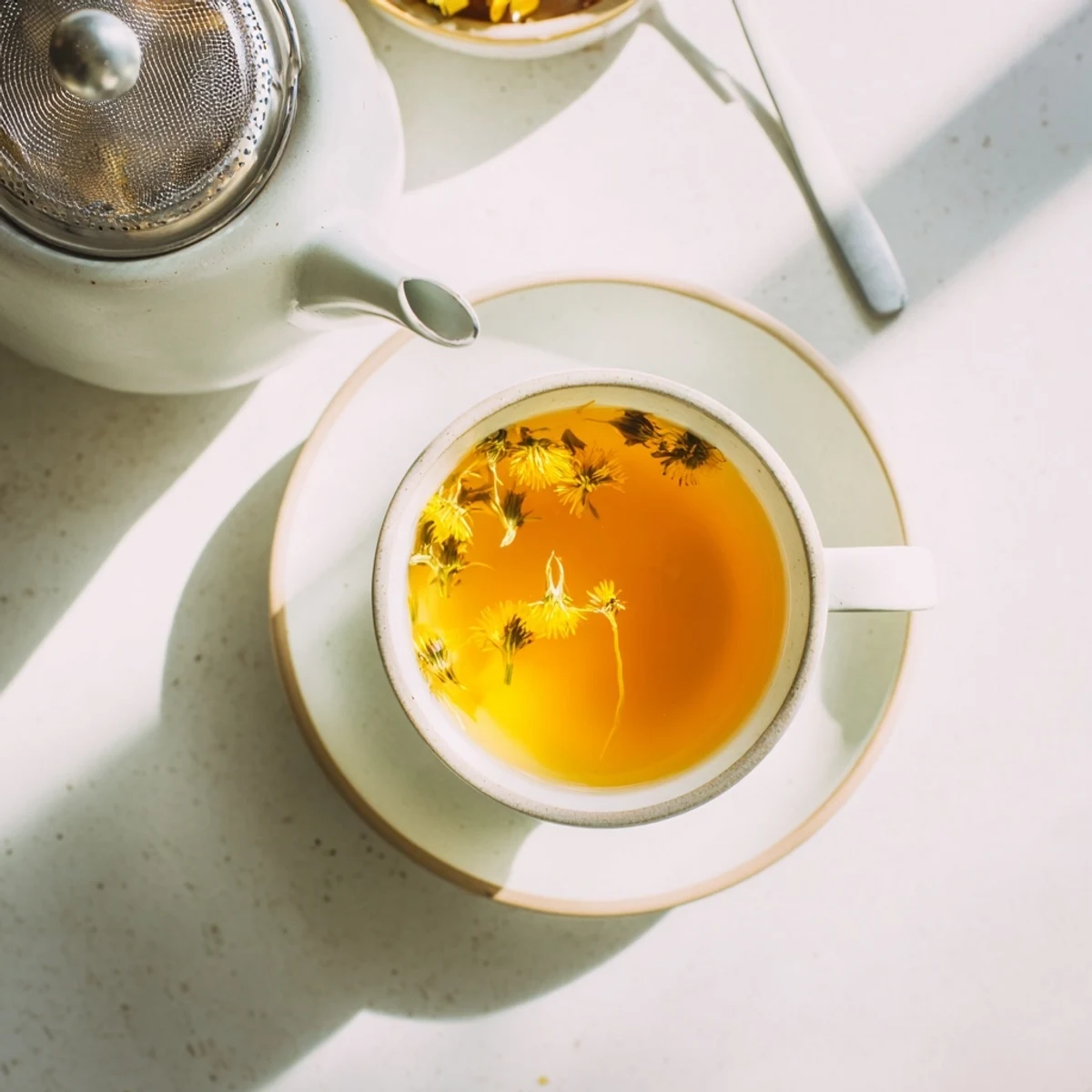 Golden dandelion tea steaming in a white ceramic mug with fresh lemon slice on saucer