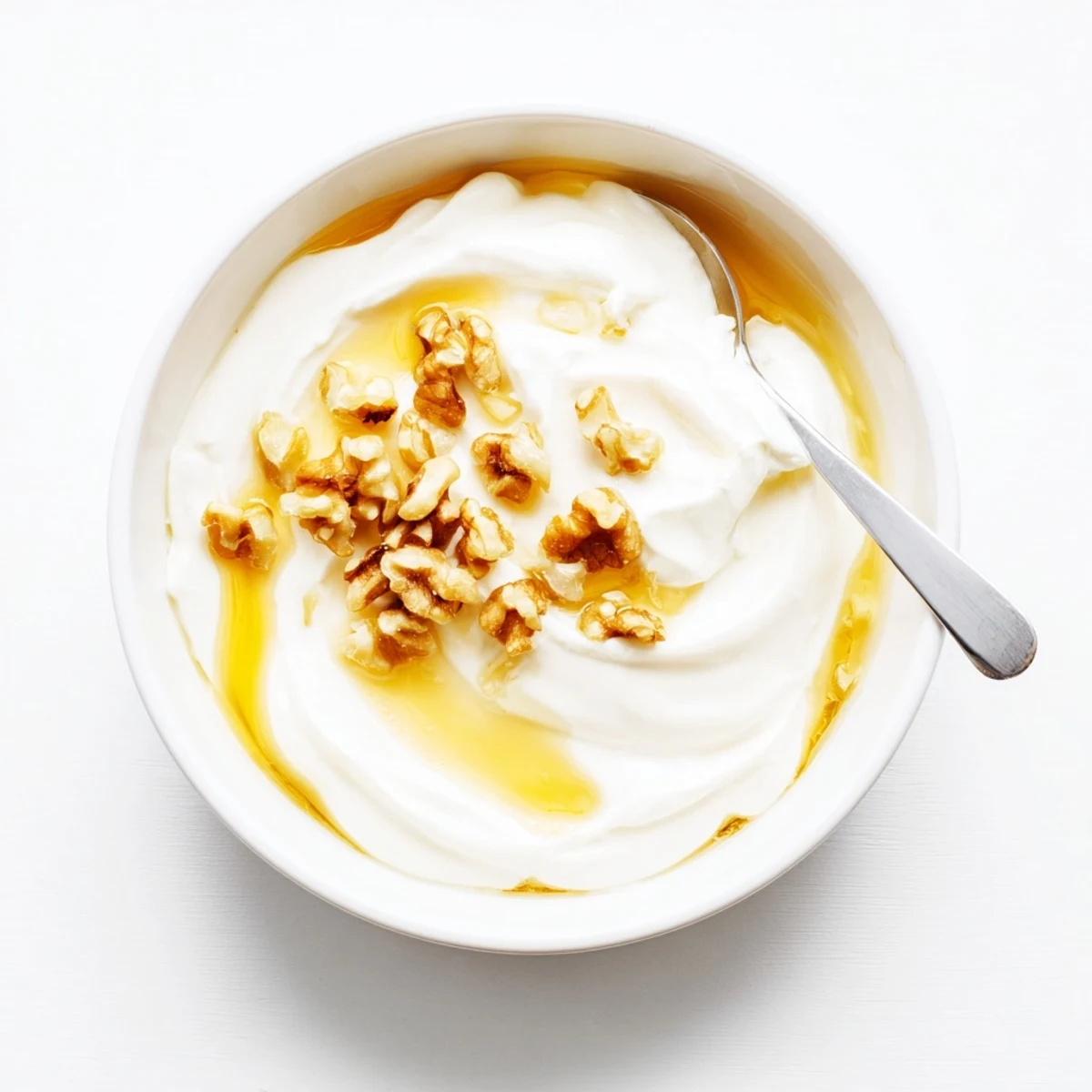 Spoonful of rich tangy Greek yogurt drizzled with golden honey and walnuts