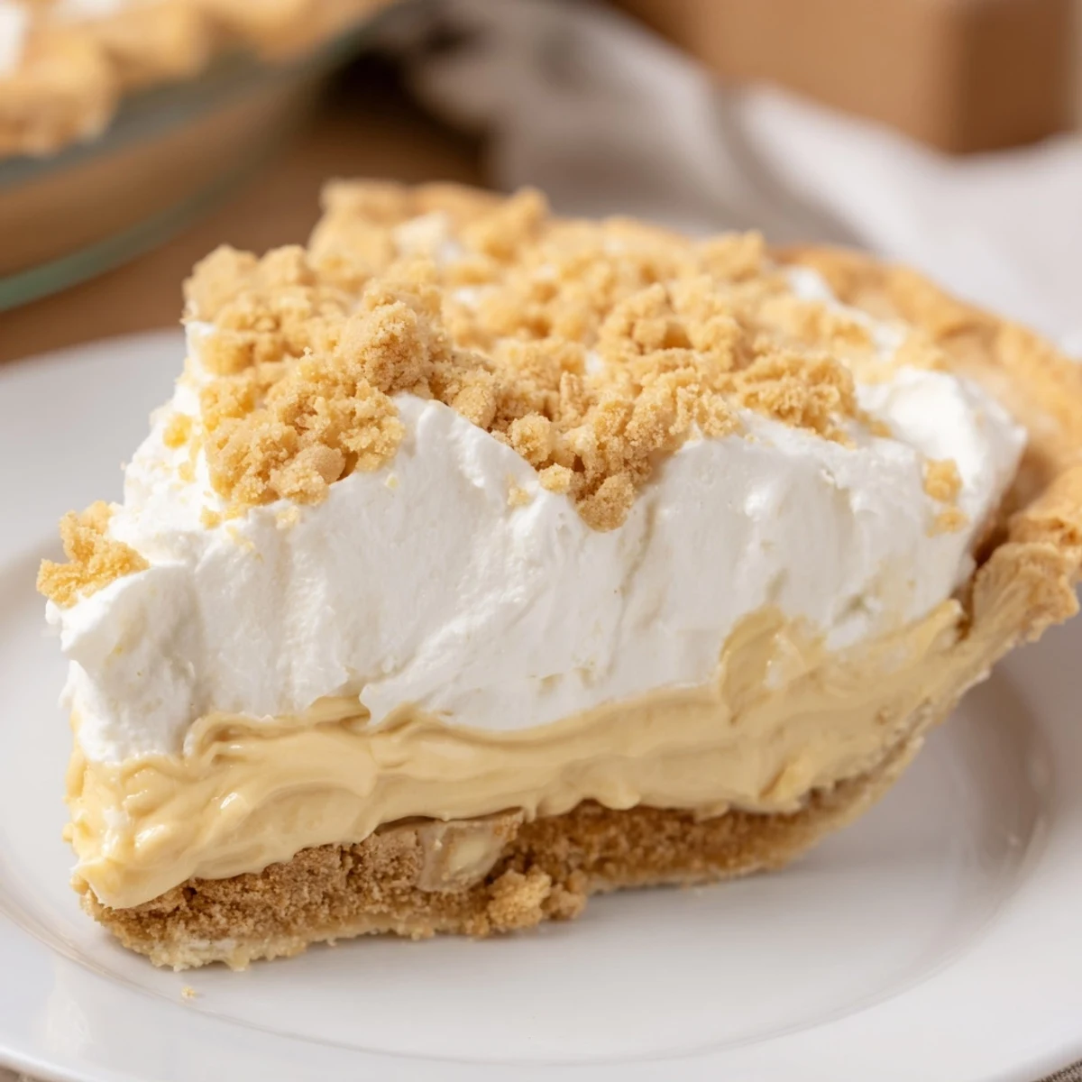 Creamy Amish peanut butter dream pie topped with fluffy whipped cream and golden crumbs