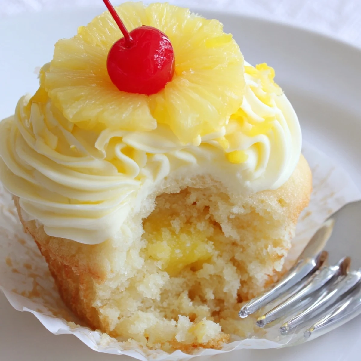 Dole Whip Cupcakes Recipe with fluffy pineapple frosting, garnished with cherry