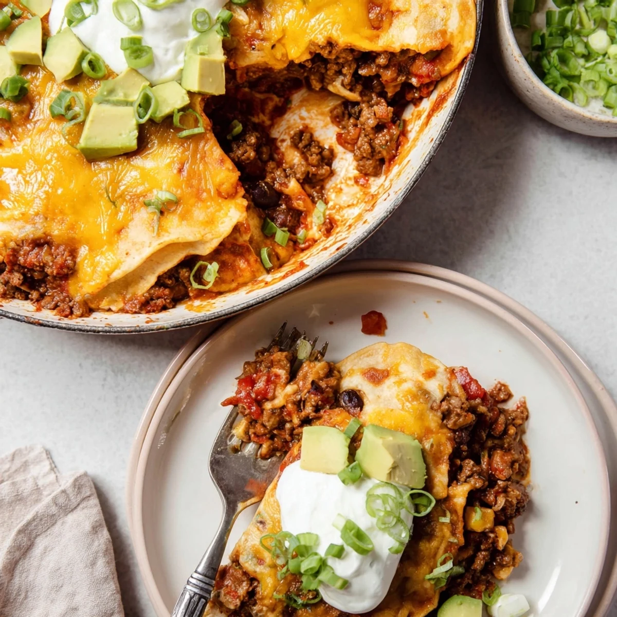 Beef Skillet Enchiladas bubbling in skillet with melted cheese and cilantro