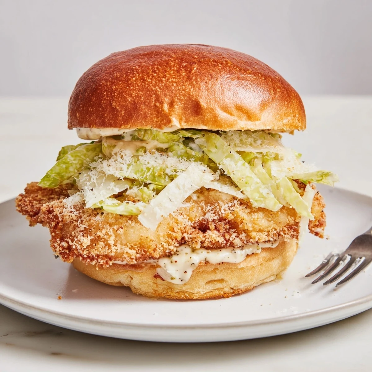 Close-up of Crispy Chicken Caesar Sandwich Recipe with creamy dressing and warm bun.