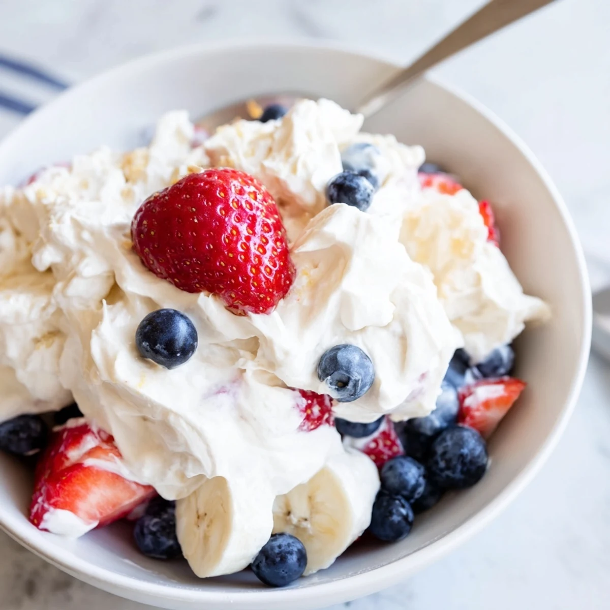 Chilled Red White And Blue Cheesecake Salad perfect for patriotic summer potlucks.