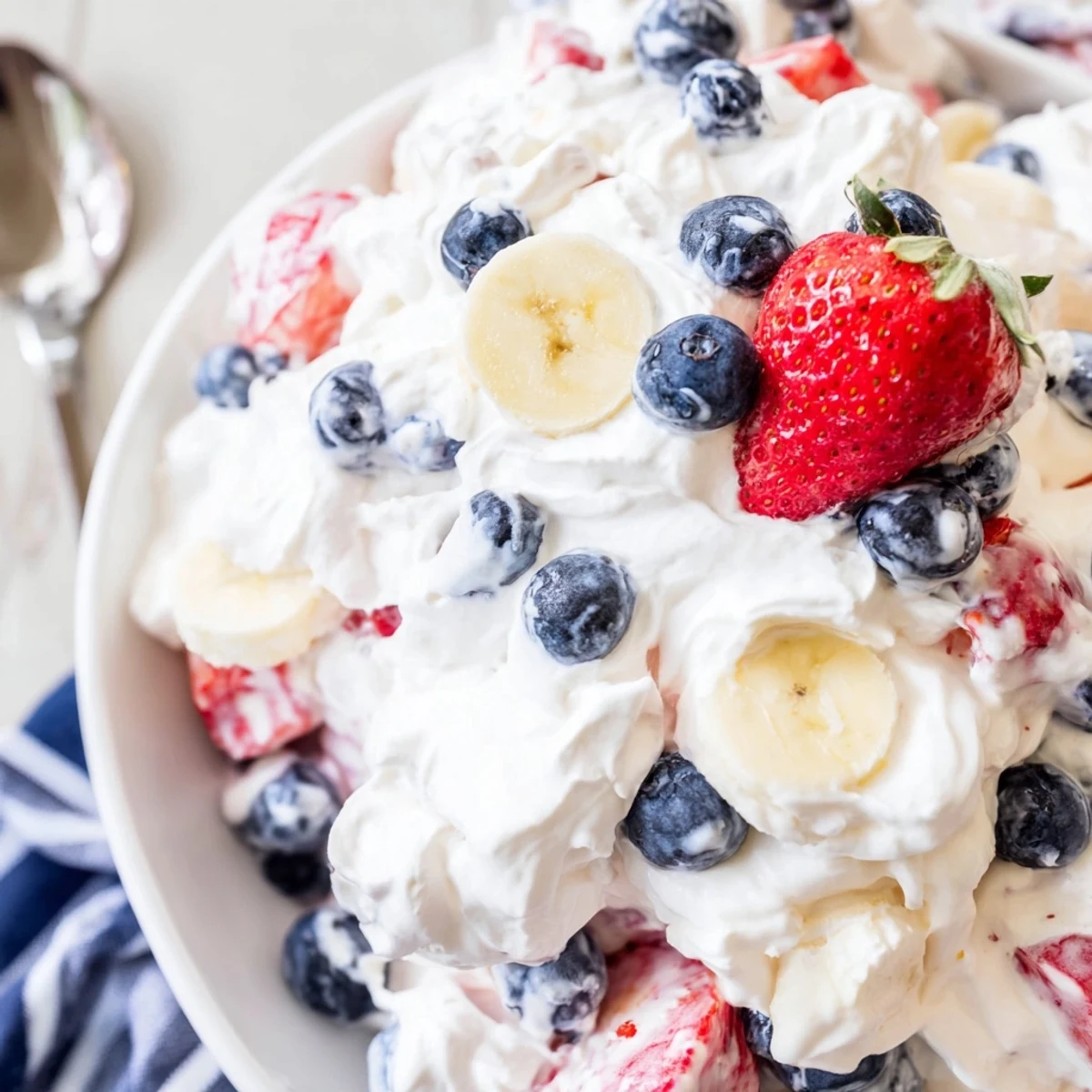 Creamy Red White And Blue Cheesecake Salad with juicy berries and bananas.