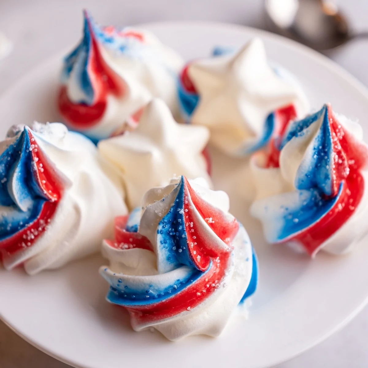 Tray of delicate Patriotic Meringue Kisses with glossy peaks, great party favors