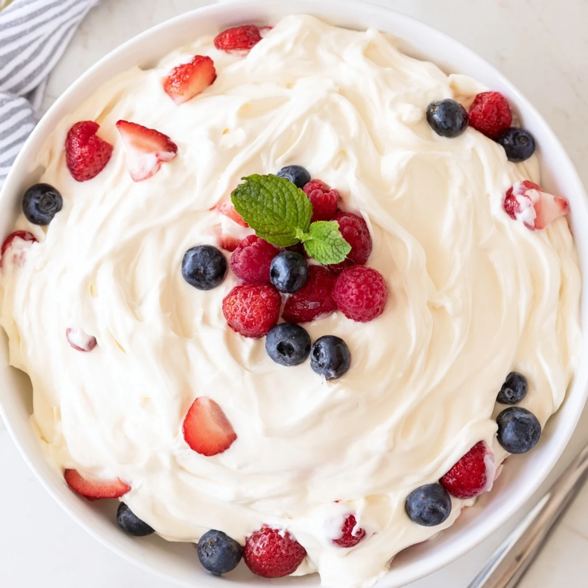 Chilled Red White Blue Cheesecake Salad with fluffy cream, vibrant strawberries  