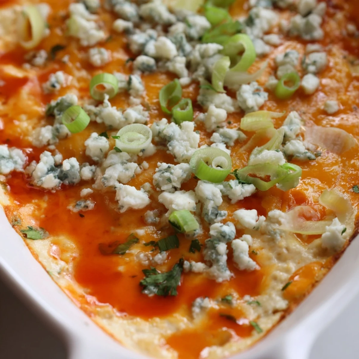 Steaming white bean buffalo appetizer sprinkled with parsley served alongside crispy tortilla chips
