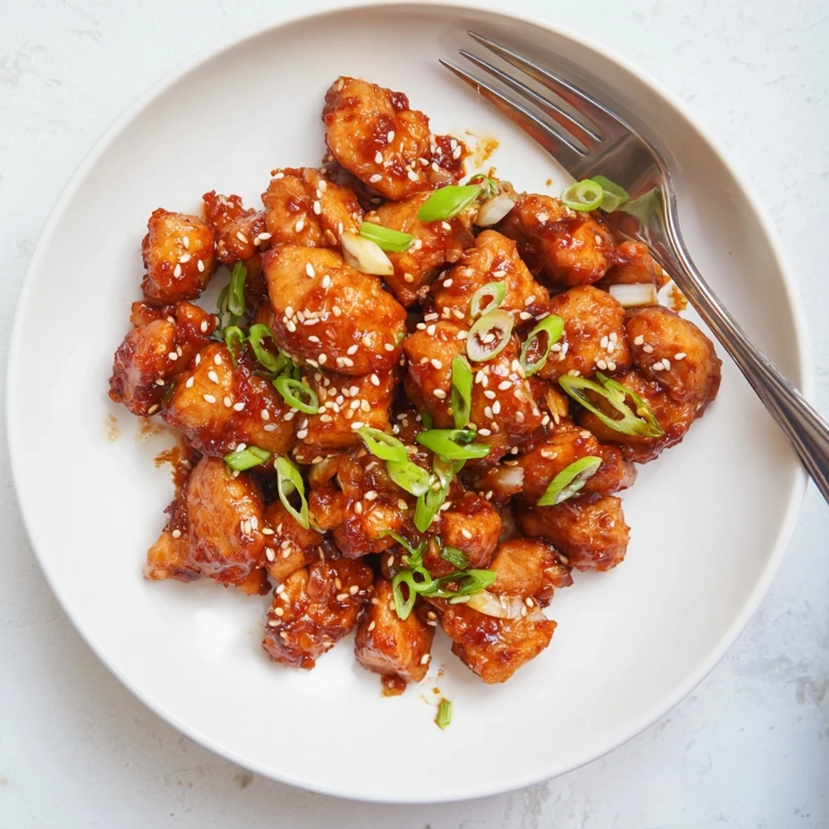 Weeknight dinner bowl featuring ground chicken in thick reddish-brown Asian sauce served over fluffy white rice