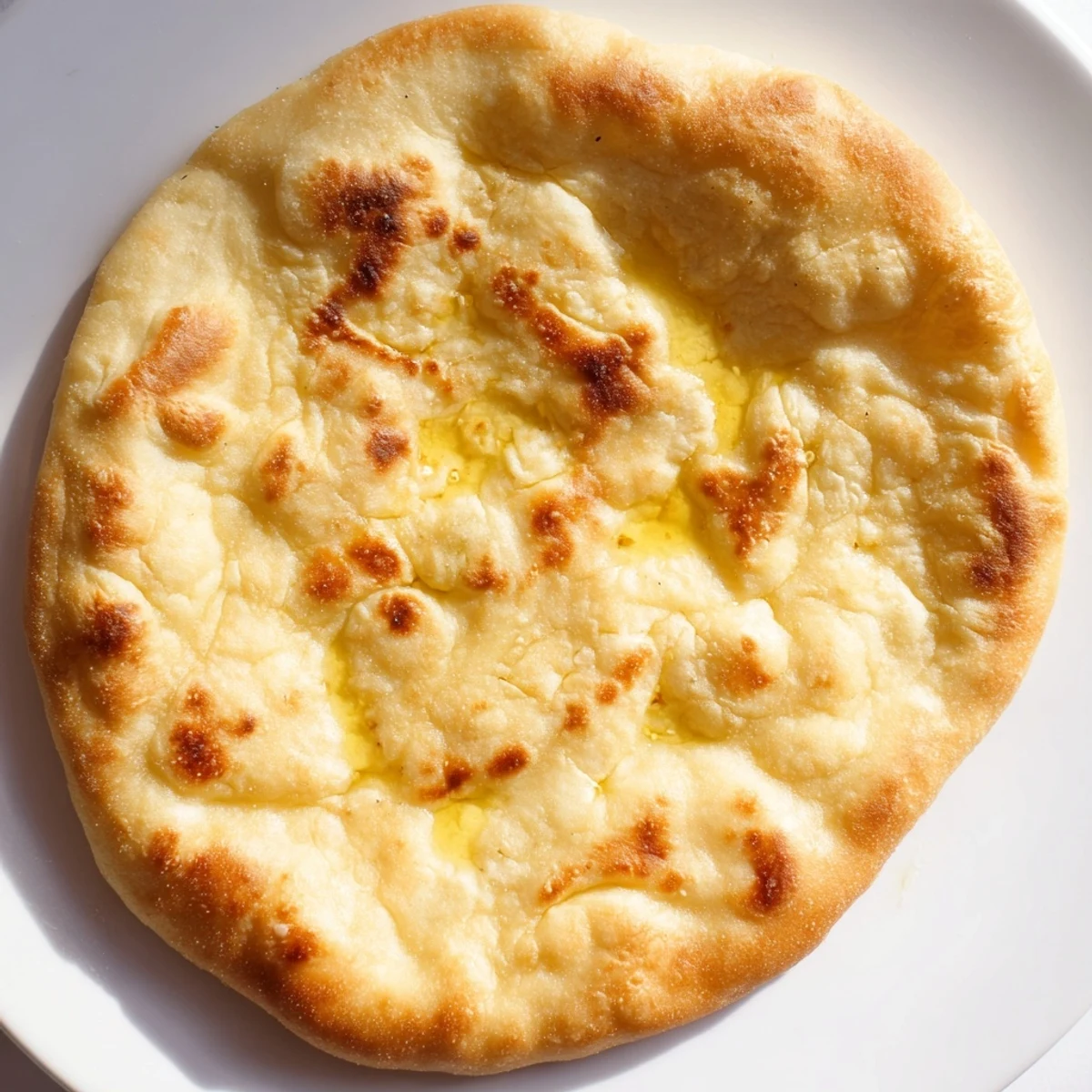 Warm Turkish Bazlama flatbread stack with slightly chewy texture, brushed with olive oil and ready for serving