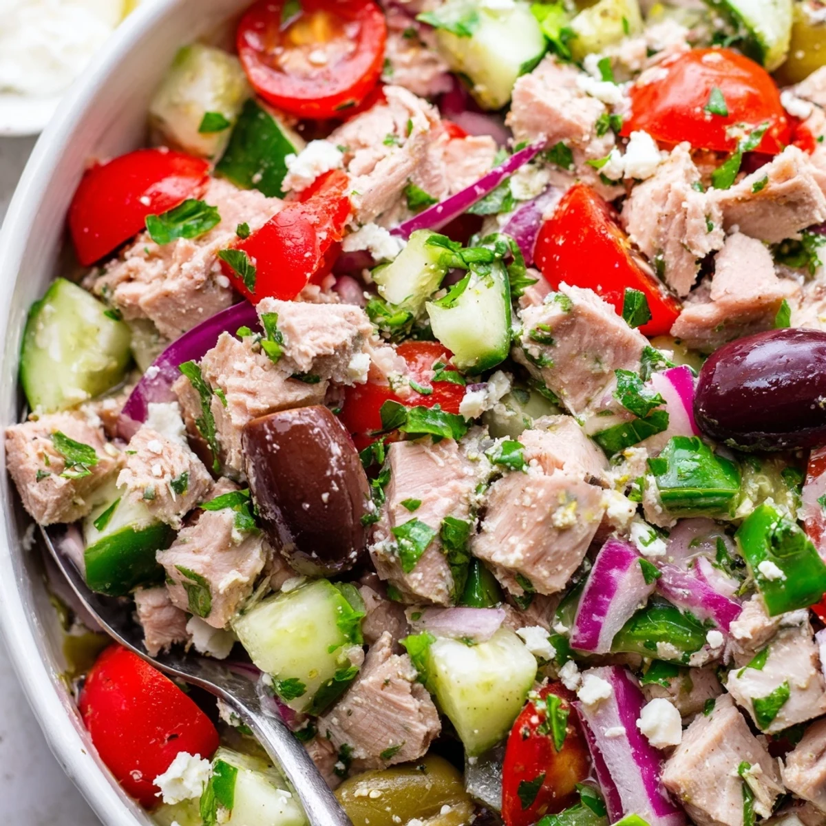 Colorful bowl of Mediterranean tuna salad featuring flaky tuna, cherry tomatoes, cucumber, and feta cheese ready for lunch