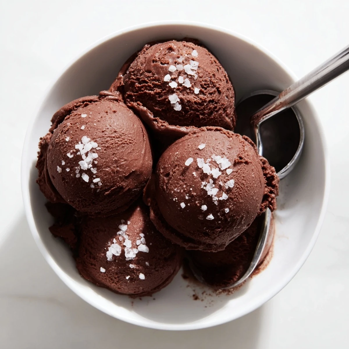 Creamy chocolate sourdough ice cream scooped into a chilled bowl with dark chocolate shavings sprinkled on top