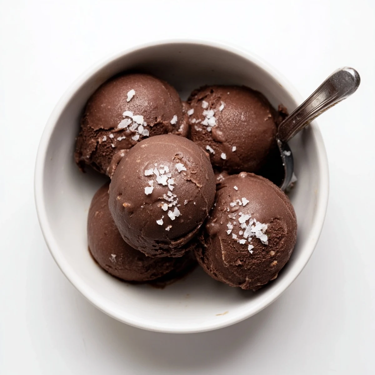 Rich chocolate sourdough ice cream swirled in a vintage glass dish showcasing its luscious velvety texture