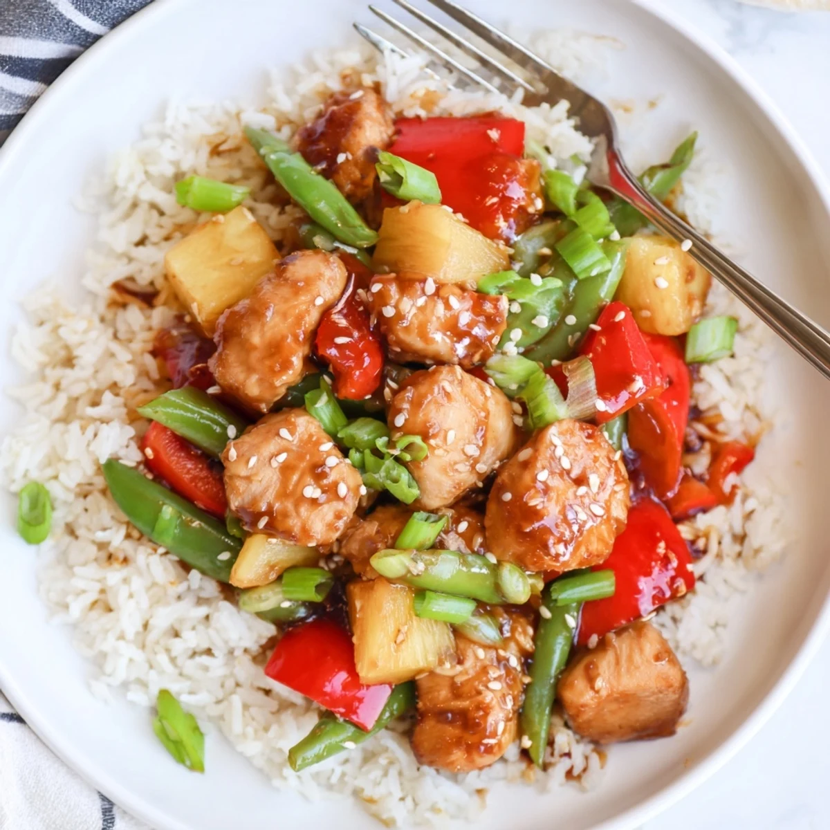 Steaming Pineapple Chicken And Rice in bowl topped with green onions