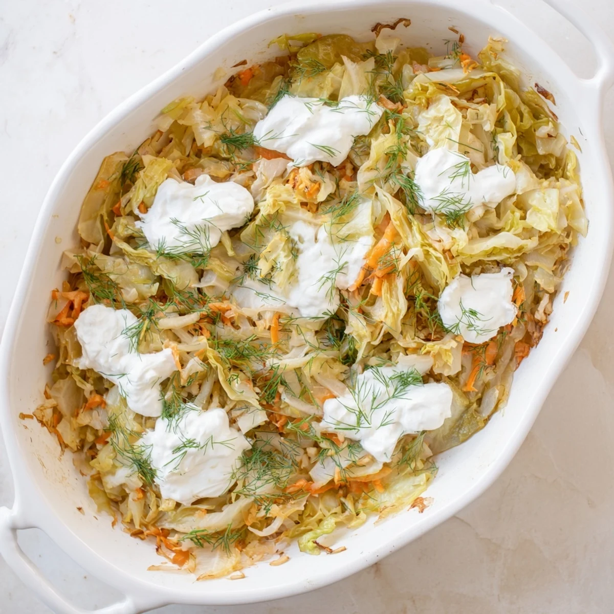 Golden brown slow roasted cabbage and sauerkraut casserole topped with fresh green dill garnish