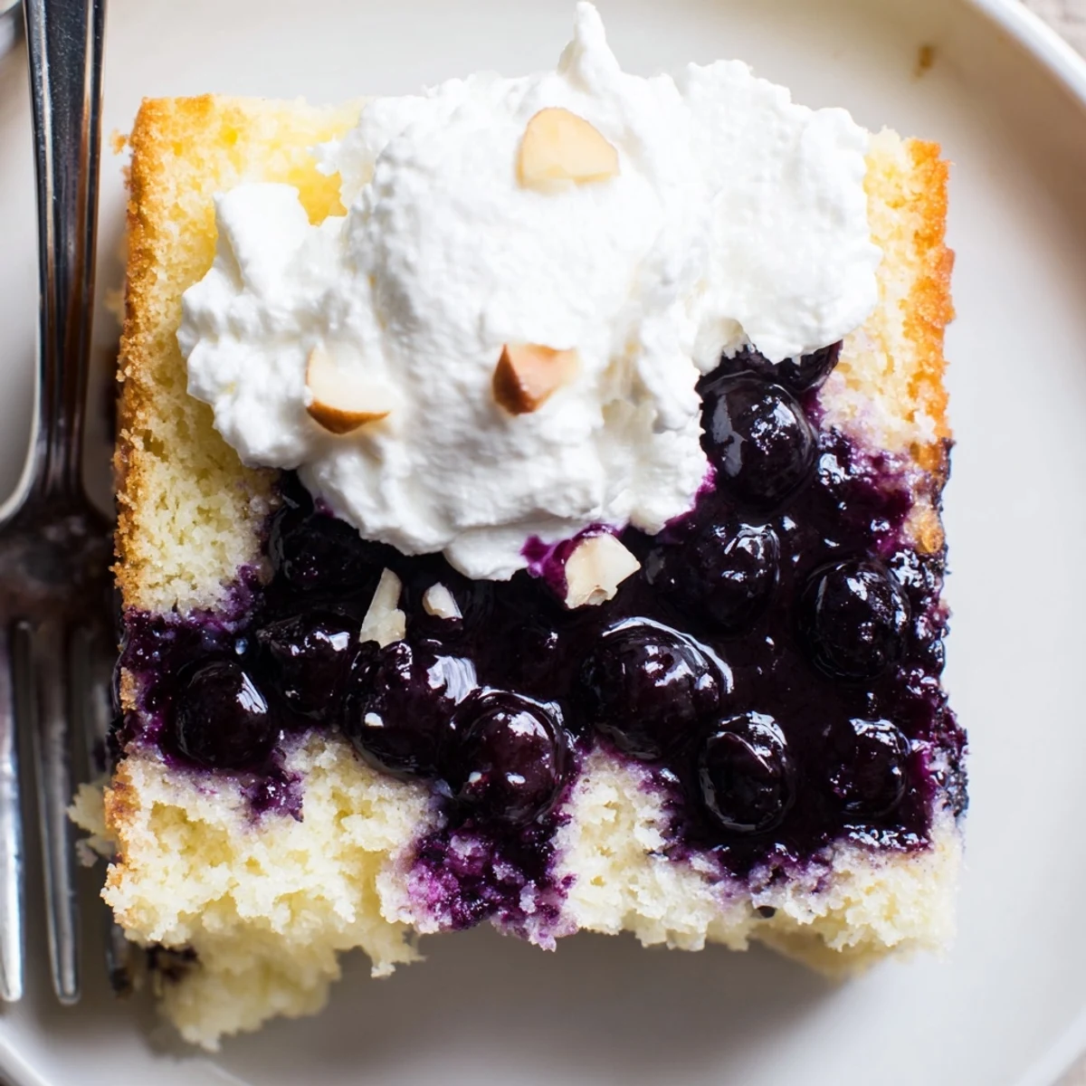Lemon Blueberry Poke Cake With Almond Topping, glossy blueberry pockets and toasted almonds
