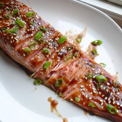 Golden baked Asian salmon fillets drizzled with sticky sauce and fresh scallions